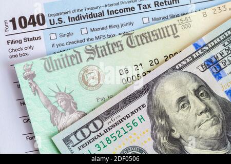 Hundert Dollar Rechnung mit Steuerrückerstattung Scheck und Formular 1040. Stockfoto
