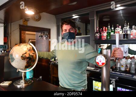 Jason Farr der Vermieter des Cross Keys Hotels mit Ein Fuß in England und der andere in Wales in Llanymynech das Dorf, das England und überspannt Stockfoto