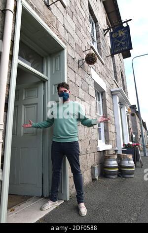 Jason Farr der Vermieter des Cross Keys Hotels mit Ein Fuß in England und der andere in Wales in Llanymynech das Dorf, das England und überspannt Stockfoto