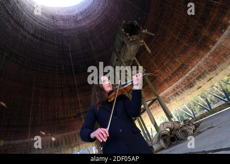 Geigerin Zoe Beyers spielt im Ironbridge Cooling Tower 2019 kurz bevor sie abgerissen wurden. Stockfoto