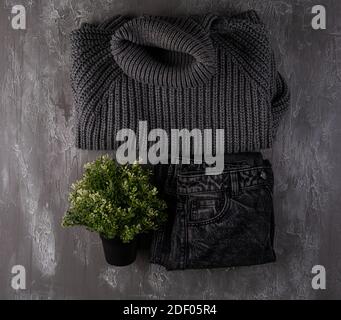 Herbst- und Wintersaison Mode Kleidung. Grauer Wollpullover, Jeans. Draufsicht Fotografie, flache Lay-Komposition. Herbst monochrome Kleidung Hintergrund Stockfoto