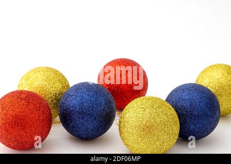 Weihnachtskugeln blau, rot und gelb auf weißem Hintergrund. Selektiver Fokus, Kopierbereich Stockfoto