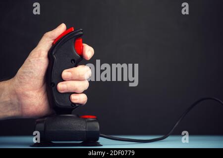 Eine Person, die Videospiele mit einem Retro-Joystick aus der Mitte der 1980er Jahre spielt. Nahaufnahme. Stockfoto