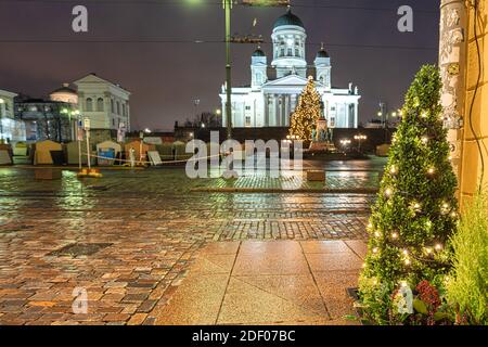 Helsinki, Finnland 30. November 2020 Stadtzentrum, historische Gebäude und eine vorbeifahrende grüne Straßenbahn. Brennende Laternen und Reflexionen nach dem Regen. Hochwertige Fotos Stockfoto
