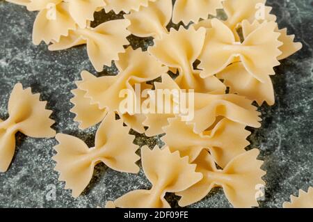 Ungekochte Pasta-Farfalle auf dem Tisch. Blick von oben. Hochwertige Fotos Stockfoto