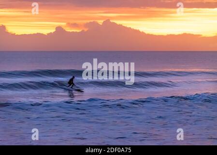 Einsitzender Surfer bei Sonnenaufgang bei Mickler's Landing in Ponte Vedra Beach, Florida. (USA) Stockfoto