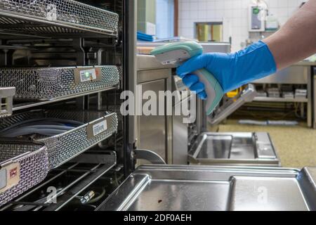Der Mitarbeiter des Krankenhauses scannt die Geräteschalen mit einem Barcode-Scanner Stockfoto