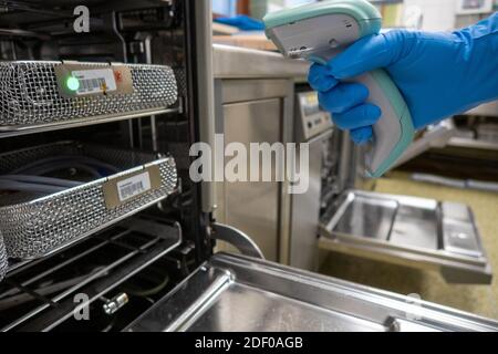 Der Mitarbeiter des Krankenhauses scannt die Geräteschalen mit einem Barcode-Scanner Stockfoto