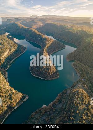 Kloster Sant Pere de Casserres bei Sonnenuntergang. Das Kloster ist vom Fluss Ter umgeben. Stockfoto