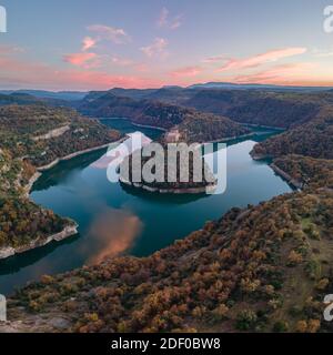 Kloster Sant Pere de Casserres bei Sonnenuntergang. Das Kloster ist vom Fluss Ter umgeben. Stockfoto