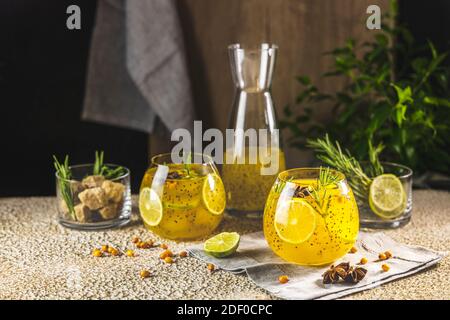 Sanddorn-Eistee oder Limonade mit Limette, Rosmarin, Sternanis und Chiasamen. Tropisches erfrischendes kaltes Getränk für den Sommer Stockfoto