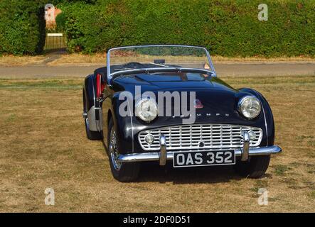 .Classic Black Triumph TR3 EIN Auto auf Dorfgrün geparkt. Stockfoto