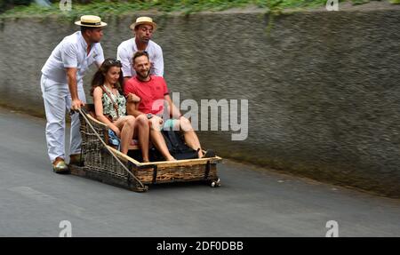 Funchal Madeira Pärchen, die den Korb bergab fahren. Stockfoto