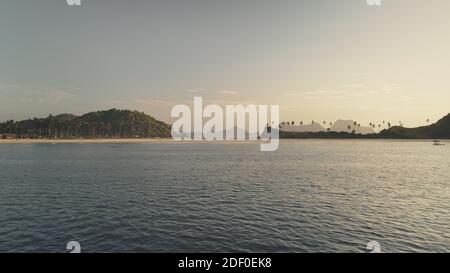 Niemand Seestück der Berge mit grünem Tropenwald an der Sandstrandantenne. Ocean Bay mit sandiger Küste und Palmen auf Hügeln. Philippinen paradiesische Inseln von El Nido. Drohnenaufnahme im Kino Stockfoto