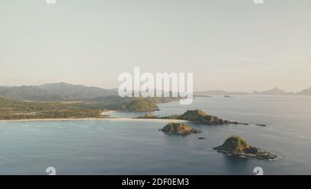 Paradiesische Seestück am Meeresufer Luftaufnahme. Schiffe, Boote im Hafen. Sandstrand mit grünen Palmen. Berge Inseln am Meer Bucht. Niemand Natur tropische Landschaft. Aufnahme mit Sonnenlicht wie im Kino Stockfoto