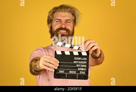 Film ansehen. Filmregisseur. Schauspielerei. Aufnahmeszene. Lieblingsserie. Kinoproduktion. Kreativer Produzent. Bärtiger Mann halten Film Klöppel. Filmemacher. Kopierbereich der Klapperplatine. Komödie oder Drama. Stockfoto