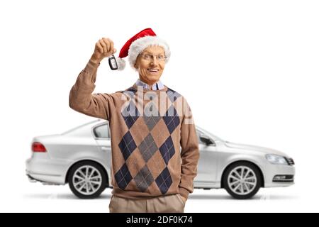 Glücklicher älterer Mann, der einen weihnachtsmütze trägt und hält Ein Schlüssel aus einem silbernen Auto isoliert auf weißem Hintergrund Stockfoto