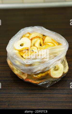 Eine Nahaufnahme einer Packung getrockneter Apfelringe Auf einem Holztisch Stockfoto