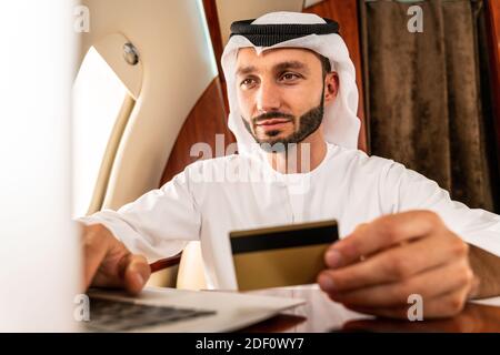 Arabischer Mann trägt eine Kandora im emirates-Stil und fliegt exklusiv Privatjet: Mittelöstlicher Geschäftsmann mit traditioneller Kleidung Exklusive BU Stockfoto
