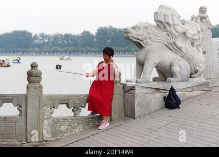 Ein Besucher macht ein Selfie auf der 17 Bogenbrücke am Sommerpalast im Nordwesten von Peking, China Stockfoto