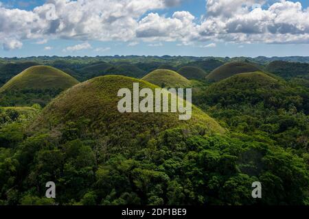 Die Chocolate Hills sind eine geologische Formation in der philippinischen Provinz Bohol, die mit grünem Gras bedeckt ist, das im Sommer braun wird. Stockfoto