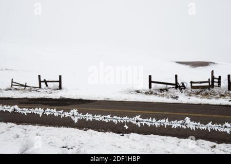 Frost Eiskristalle auf Stacheldrahtzaun mit Winterlandschaft Im Hintergrund Stockfoto