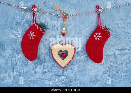 Weihnachten Hintergrund. Rote Weihnachtssocken und Herz hängen am Seil auf blauem Hintergrund. Speicherplatz kopieren. Stockfoto