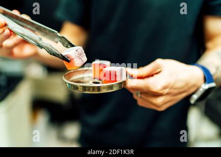 Der Kellner holt Holzkohlesteine für Shisha Stockfoto