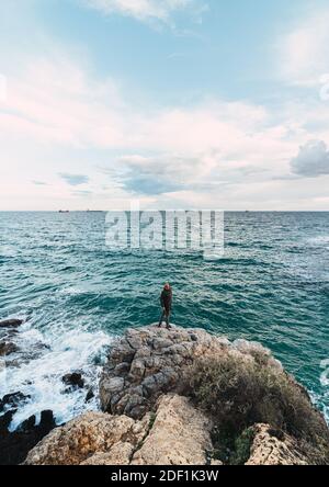 Epische Aufnahme EINES Mannes im Zentrum VON A Landschaft Mit Blick Auf Das Meer Stockfoto