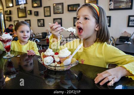 Alabama Tuscumbia the Palace Ice Cream & Sandwich Shop, Sodabrunnen Zähler Mädchen Schwestern essen Banane gespalten im Inneren, Stockfoto