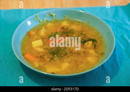 Eine vegetarische Suppe aus Kartoffeln und Karotten in einem Blaue Schale auf einem Tisch Stockfoto