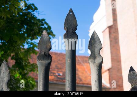 Nahaufnahme eines Metallzauns mit Dächern Der Hintergrund Stockfoto