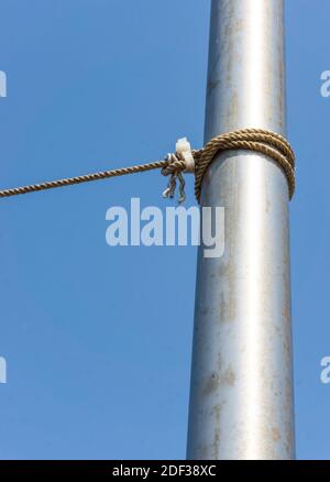 Ein dickes Seil, das mit dem blauen Seil um das Rohr gebunden ist Himmel im Hintergrund Stockfoto