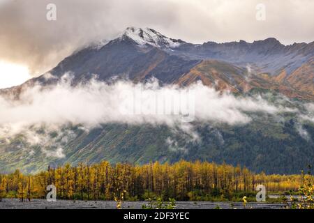 Wolken sammeln sich über den Kenai Mountains mit farbenfrohem Herbstlaub vom Glacier View Blick auf den Kenai Fjords National Park in der Nähe von Seward, Alaska. Stockfoto