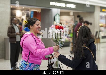 Eine Frau erhält einen Blumenstrauß, als sie von Dubai nach einem 14-stündigen Flug auf Emirates Flug 231 am internationalen Terminal am Dulles International Airport in Dulles, VA, USA, Montag, 16. März 2020 ankommt. Einige Leute nehmen die Vorsorge des Tragens von Gesichtsmasken, wie sie ankommen, um von Familie und oder Freunden begrüßt zu werden. Foto von Rod Lampey/CNP/ABACAPRESS.COM Stockfoto