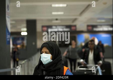 Ein Mitarbeiter am Dulles International Airport unterstützt Passagiere bei der Ankunft von Dubai nach einem 14-stündigen Flug auf Emirates-Flug 231 am internationalen Terminal am Dulles International Airport in Dulles, VA, USA, Montag, 16. März 2020. Einige Leute nehmen die Vorsorge des Tragens von Gesichtsmasken, wie sie ankommen, um von Familie und oder Freunden begrüßt zu werden. Foto von Rod Lampey/CNP/ABACAPRESS.COM Stockfoto