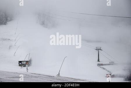 Oberwiesenthal, Deutschland. Dezember 2020. Schneekanonen sprühen Kunstschnee auf die Piste am Fichtelberg. Die sächsischen Wintersportregionen haben den Dezember aufgrund von Koronabeschränkungen abgeschrieben, rüsten sich aber für die folgenden Wintermonate. Auf jeden Fall wollen sie vorbereitet sein, falls die Skigebiete wieder geöffnet werden können. Quelle: Jan Woitas/dpa-Zentralbild/dpa/Alamy Live News Stockfoto