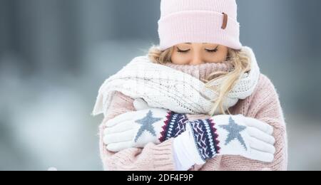 Eiskalte Frau in wollige Kleidung an einem Wintertag gekleidet, bis zur Nase bedeckt. Stockfoto