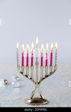 Jüdischer Kerzenständer Menorah mit brennenden Kerzen auf weißem Hintergrund. Chanukka Urlaub. Stockfoto