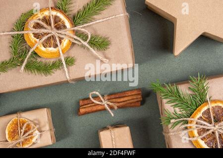 Komposition zu Weihnachten oder Neujahr. Schachteln mit Bastelpapier, getrockneten Orangen, Fichtenzweigen und natürlichem Dekor. Konzept Zero Waste, Öko Frien Stockfoto