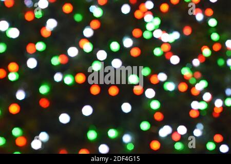 Weihnachten Hintergrund, Girlande in Unschärfe. Leuchtende und festliche farbige Lichtkreise in Kamera und Bokeh-Objektiv. Weihnachtsmärchen Lichter sind Unschärfe Stockfoto