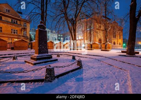 uzhhorod, ukraine - 26 DEC 2016: Winterstadtbild bei Sonnenaufgang. Wunderschöne Landschaft im Park bei Sinagoge. Schnee auf dem Böschung auf dem Bürgersteig Stockfoto