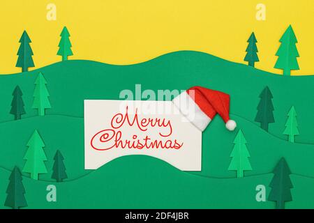Weihnachtsbaum Papier schneiden Design papercraft Karte mit Weihnachtsmann Hut. Papiergeschnittene Weihnachtsbäume. Kreative Gestaltung von weihnachten Hintergrund mit pape Stockfoto