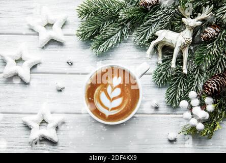 Weihnachtskarte mit Tasse Kaffee, Kiefer, Tanne auf weißem Holzhintergrund, Draufsicht Stockfoto