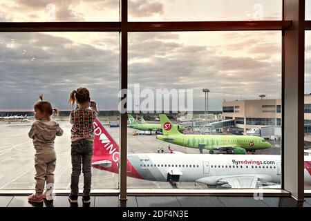 Moskau Russland-september 2020: Kinder schauen aus dem großen Fenster auf die Flugzeuge im Flughafengebäude Stockfoto