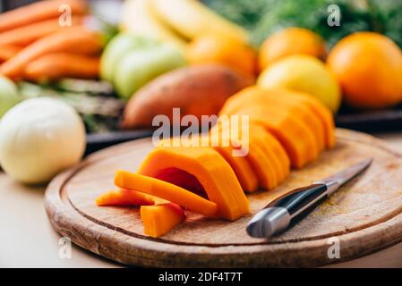 Butternut Squash Mahlzeit Vorbereitung auf Holz Küchentisch. Kochen von Speisen für traditionelle Danksagung Abendessen. Herbstliche Kürbissuppe zubereiten. Stockfoto