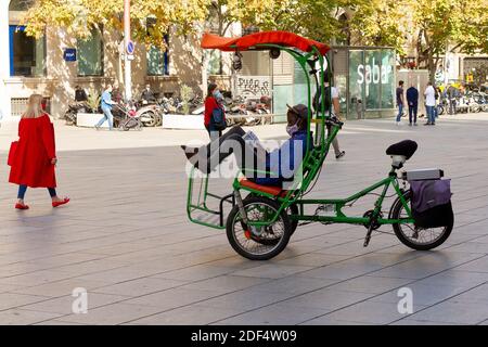 BARCELONA, SPANIEN - Nov 14, 2020: Barcelona, Spanien-November 14,2020:Junge auf seinem Fahrrad ruhend, die Menschen auf dem Platz mit seiner Maske Anti covid-19. Stockfoto