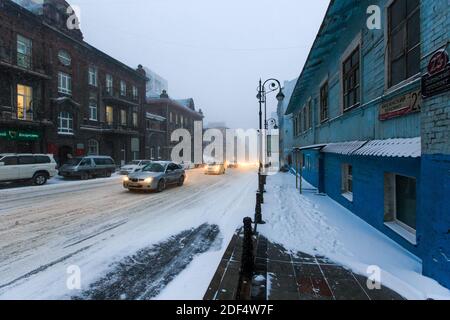 Januar, 2016 - Wladiwostok, Russland - starker Schneefall in Wladiwostok. Autos fahren bei Schneefall entlang der zentralen Straßen von Wladiwostok. Stockfoto
