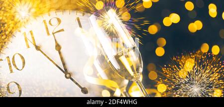 Silvesterfeier mit Sektflöten und Mitternacht Countdown auf goldenem Feuerwerk Bokeh Hintergrund. Weihnachtsfeier mit Blur Konfetti Glitter Stockfoto