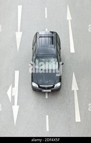 Auto von Oben zwischen Fahrbahn und Richtungspaefen Stockfoto